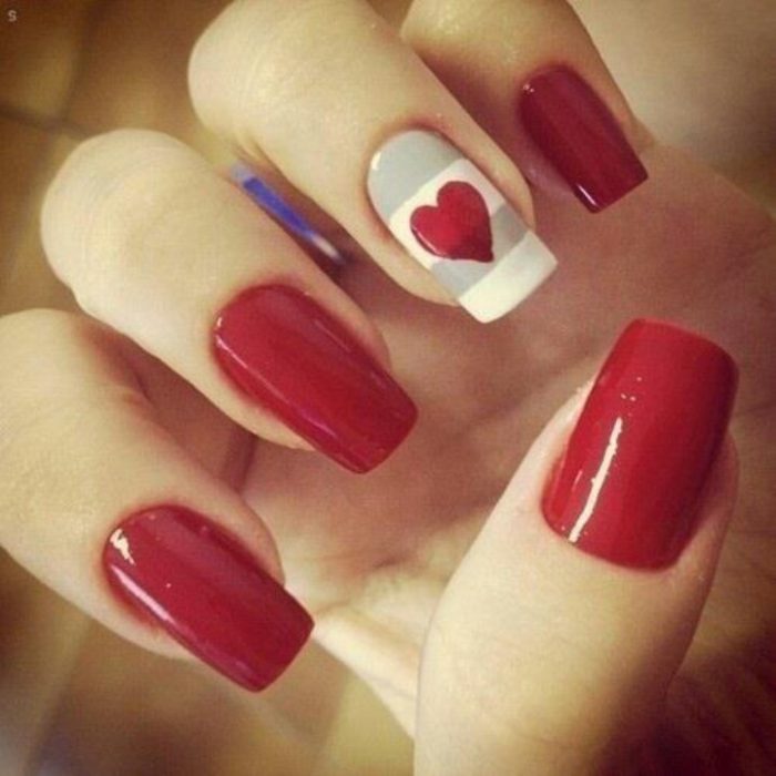 manicure rojo con una uña de corazón