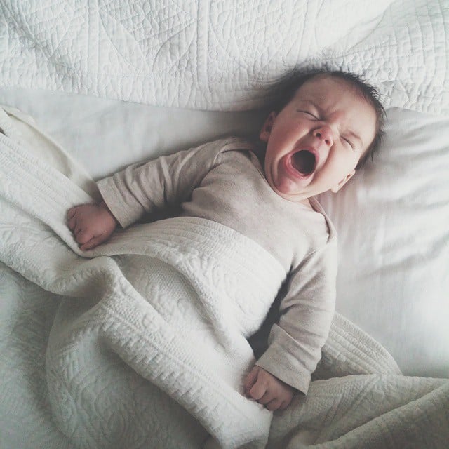 Bebé recostado en la cama llorando 