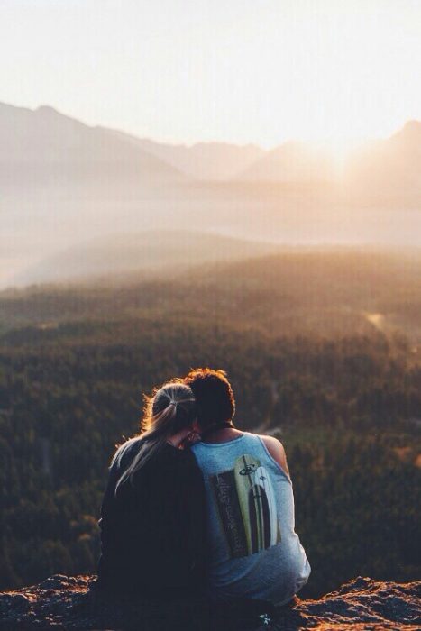 pareja mirando al horizonte en una montaña