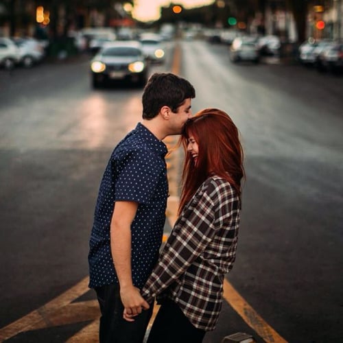 Pareja de novios besándose en medio de la carretera 