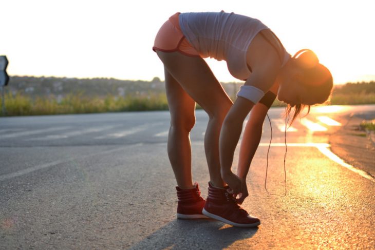 Chica a punto de correr en una carretera 