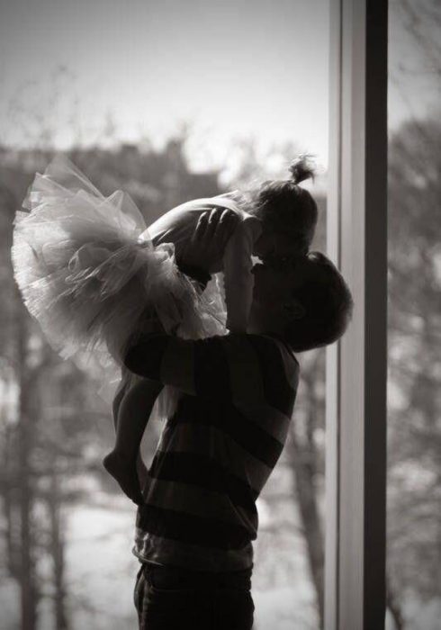 Padre cargando a su hija que practica ballet 