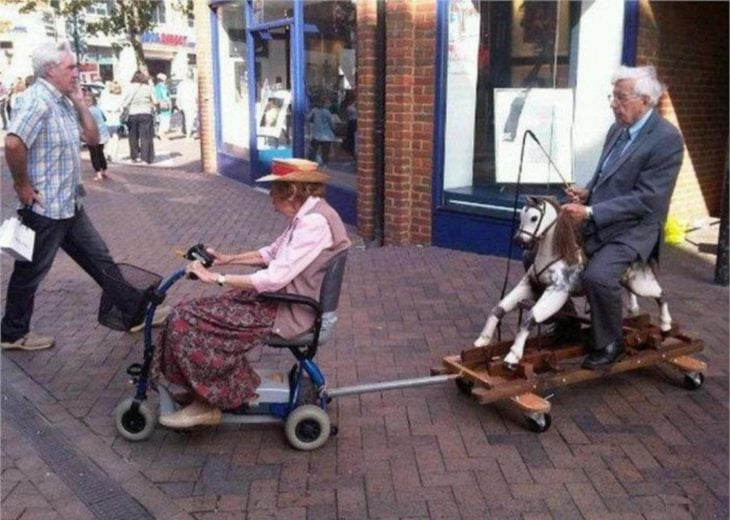 Viejitos divirtiéndose en silla de ruedas y un caballito 