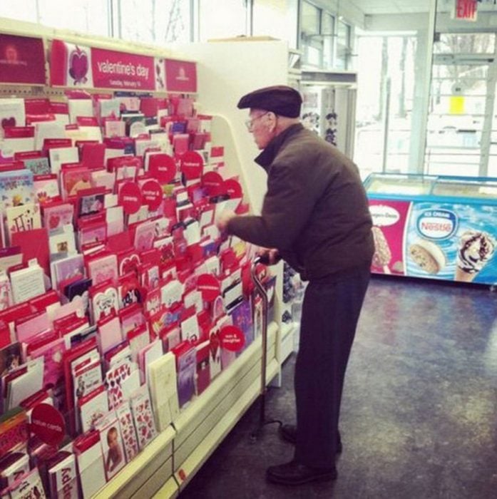 Anciano viendo tarjetas de amor 