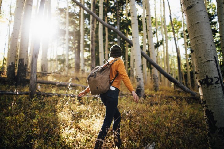 Chica caminando por el bosque