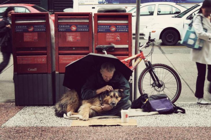 Hombre sin hogar junto a su perro 