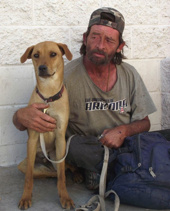 Hombre sin dinero abrazando a su perro 