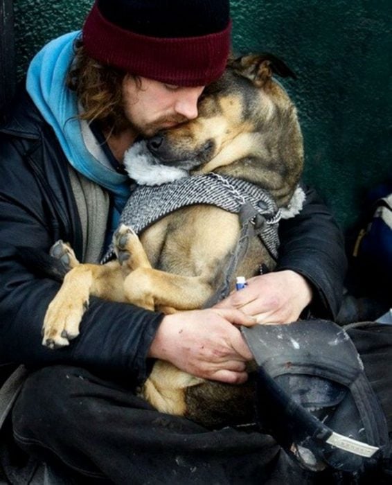 chico sin hogar abrazando a su perro 