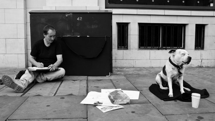 Hombre sin hogar pintando un perro 