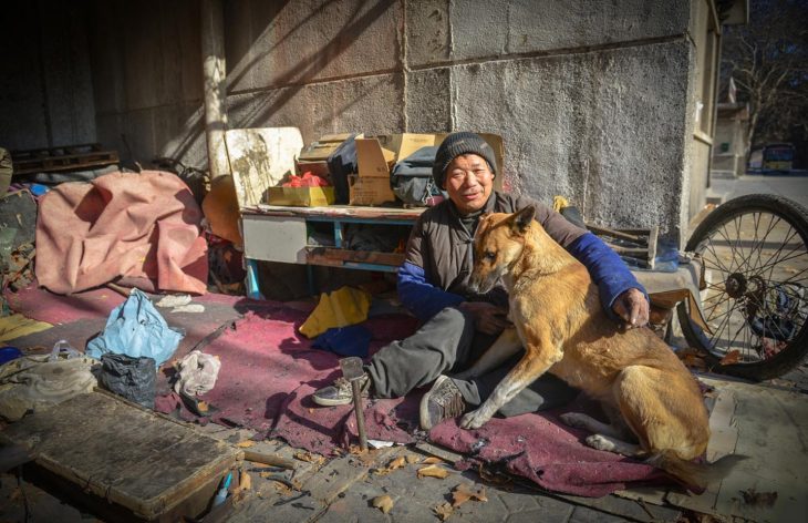 Señor sin hogar junto a su perro 