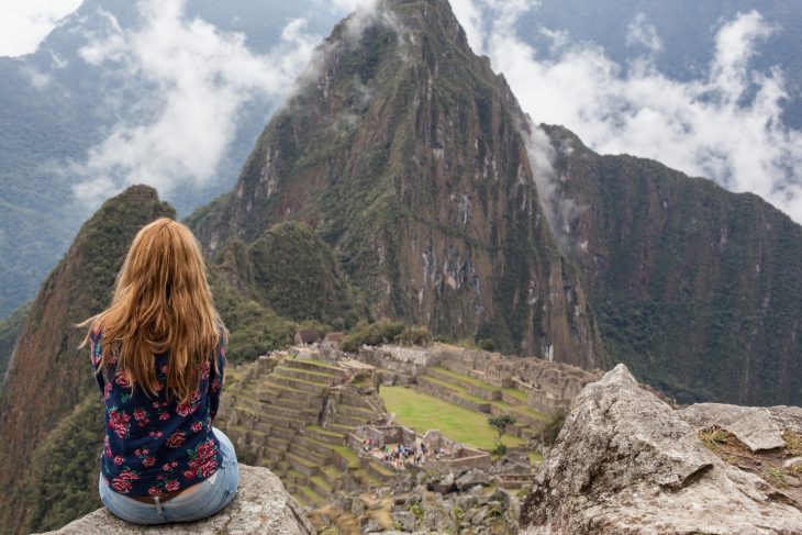 Chica sentada en una montaña reflexionando 