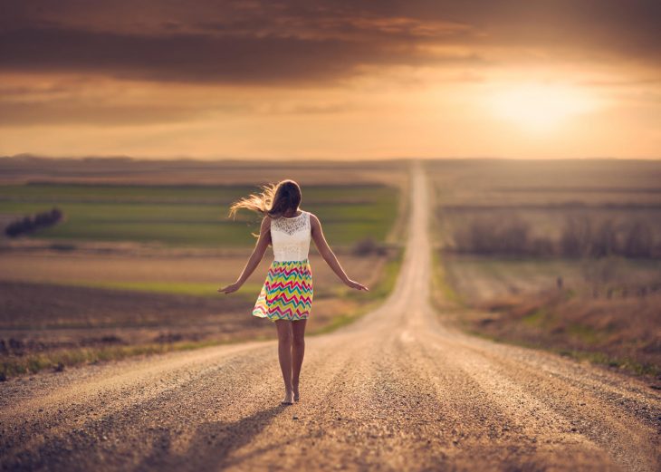 Chica caminando por la carretera 