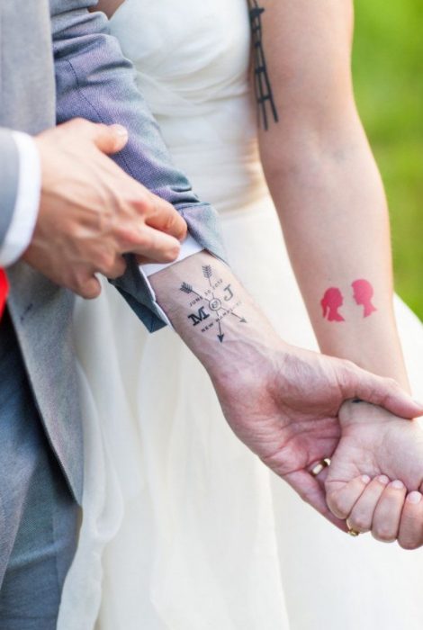 Pareja mostrando sus tatuajes de boda