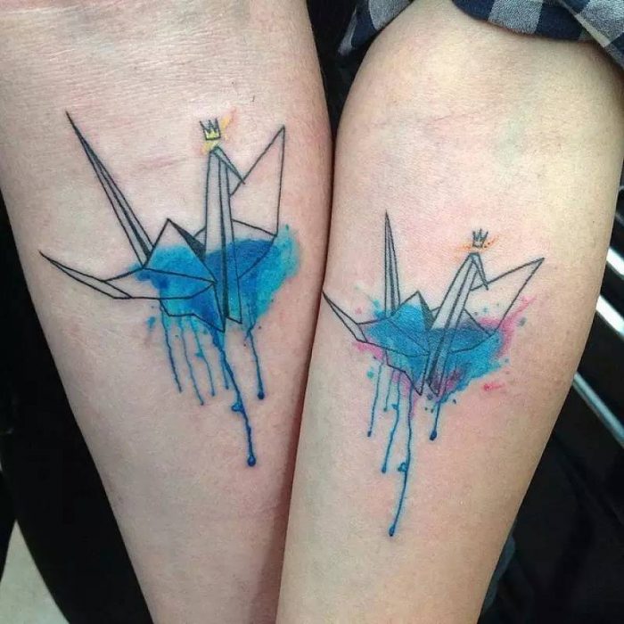 Pareja mostrando sus tatuajes de origami 