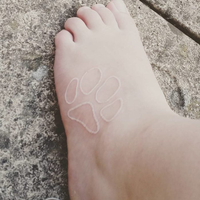 Tatuaje de huella de perro con tinta blanca 