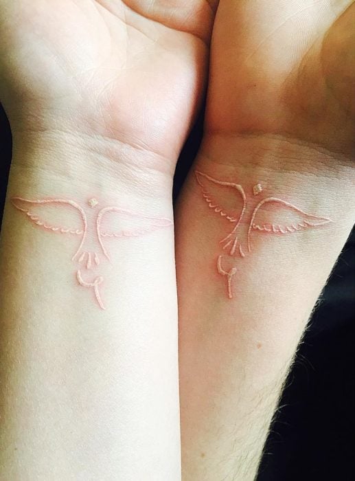 Tatuaje de pájaros con tinta blanca 