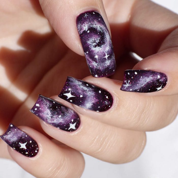 Uñas cósmicas rosas con morado y negro 