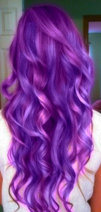 Chica de cabello morado parada de espaldas enseñándole el cabello