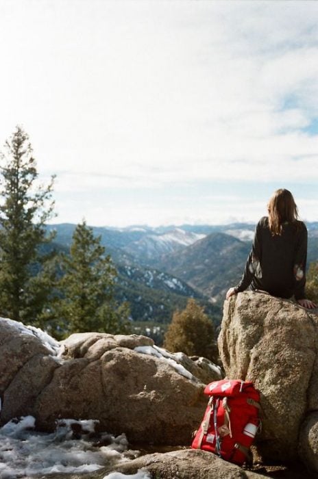 chica sola sentada en la montaña