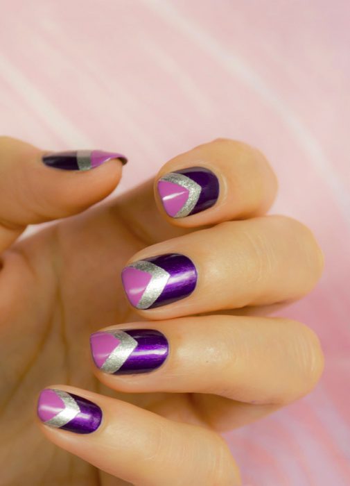 Diseño de uñas de color morado con franjas plateadas y rosas