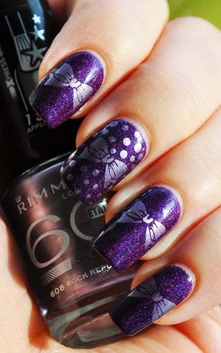 Diseños de uñas de color morado con moños en color plateado 