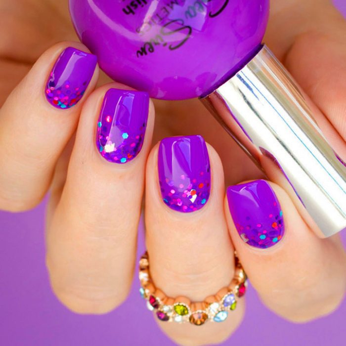 Diseño de uñas color morado con glitter color rosa 