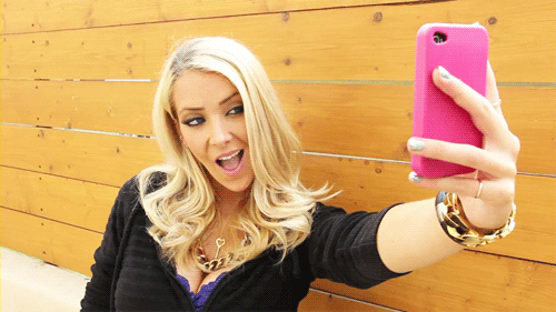 GIF Chica tomándose una selfie con su celular 