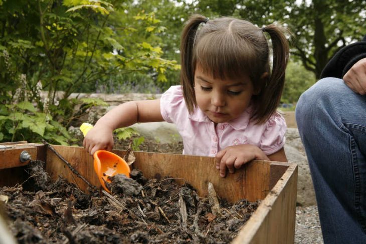 niña jugando con tierra