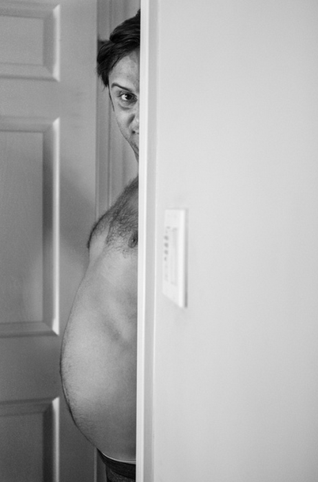 Hombre apareciendo sobre una puerta mostrando su barriga 