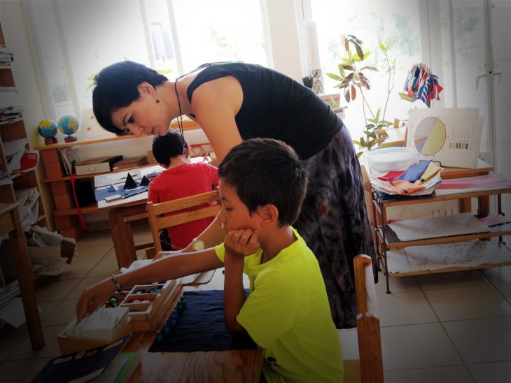 Guía Montessori trabajando con un estudiante