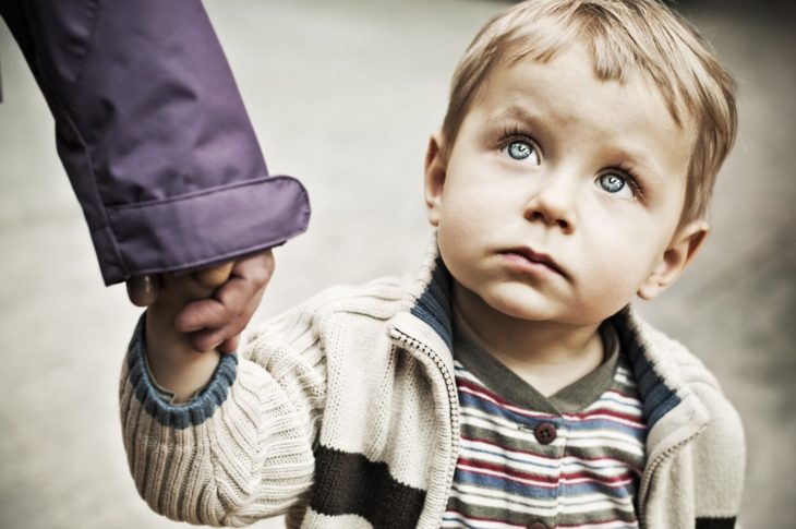 Niño toma la mano de uno de sus padres