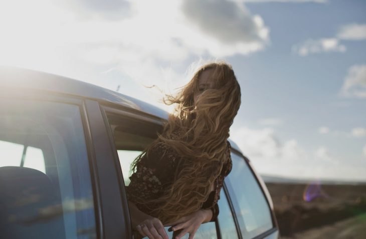 chica saliendo por la ventana de coche