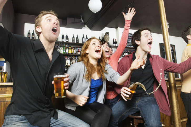 chicos viendo deportes en un bar