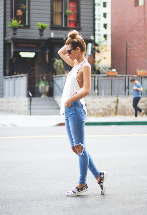 Chica caminando por la calle usando una blusa blanca y jeans 