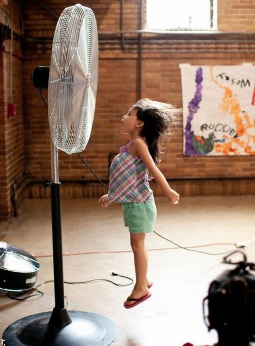 niña brincando frente al ventilador