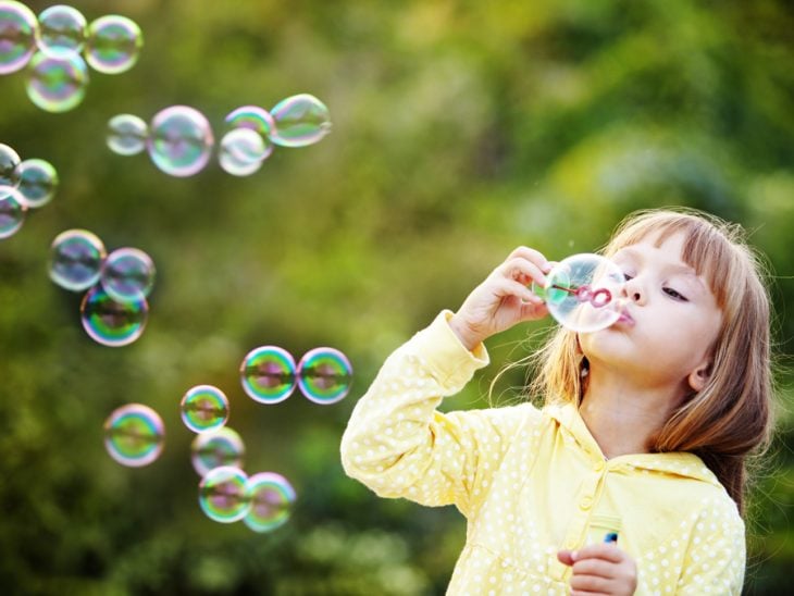 niña haciendo burbujas 
