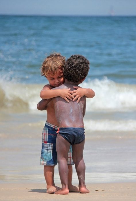 niños pequeños abrazándose en la playa