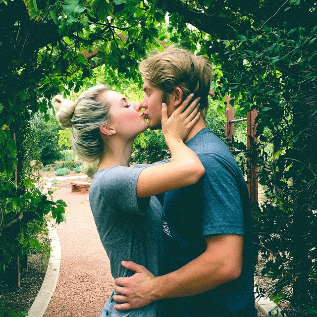 Pareja de novios besándose en un campo