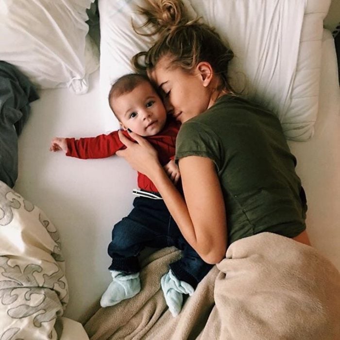 Chica y bebé acostados en una cama 