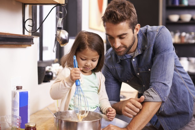 Papá y su hija pequeña cocinan