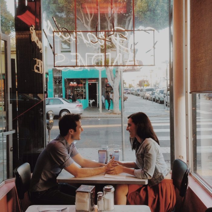 Pareja de novios conversando mientras están en un café 