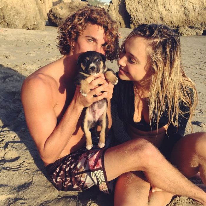 Pareja en la playa con un cachorro 