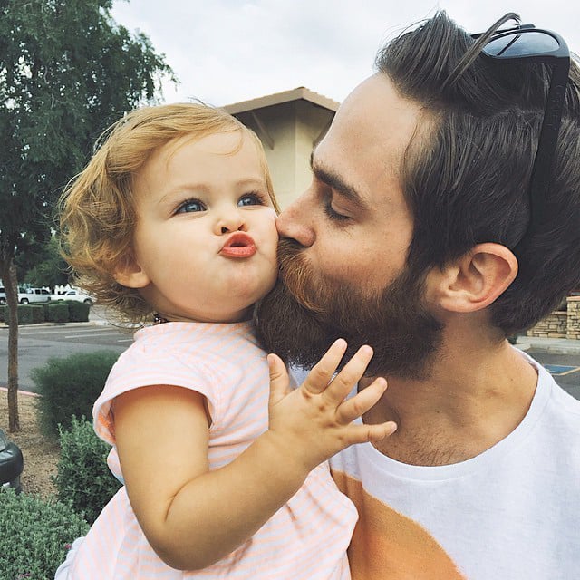 Papá dando un beso a su pequeña hija 