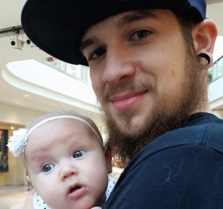 padre soltero cargando a su hija y visitando el centro comercial 