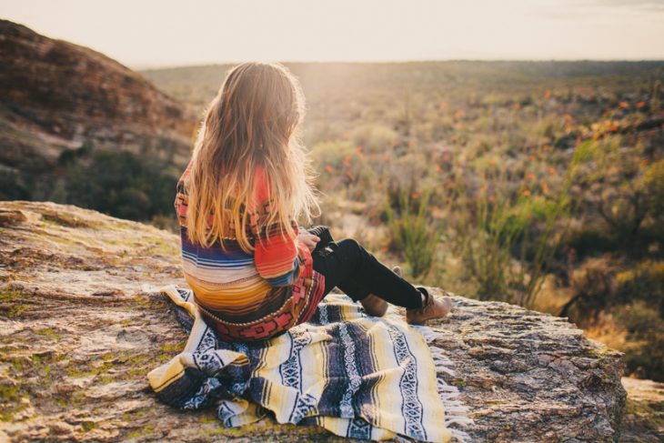 Chica en una montaña viendo el amanecer 