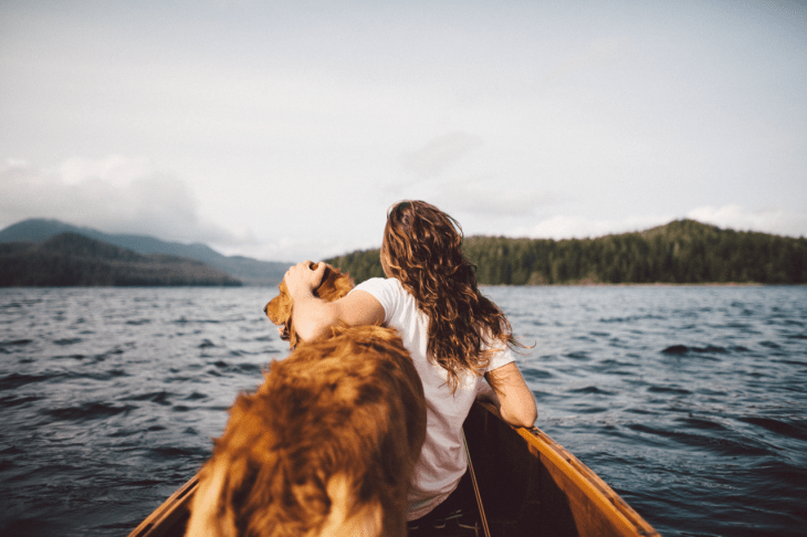 Chica en una lancha con su perro 