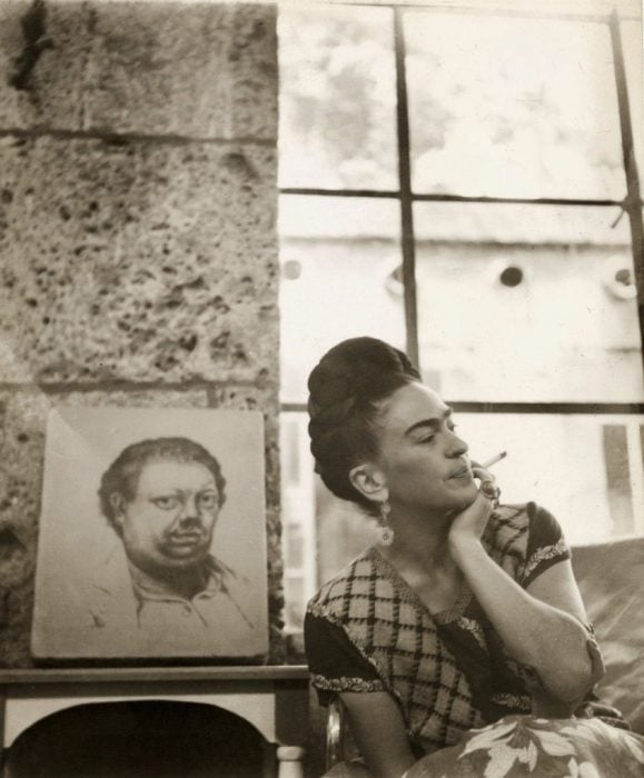 Frida Kahlo frente a un autorretrato de Diego rivera. Fotografía de Manuel Alvarez Bravo