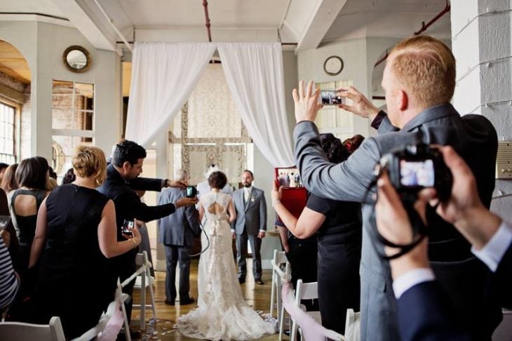 Personas tomando fotografías de una boda, interrumpiendo la ceremonia 