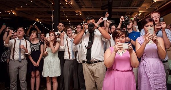 Invitados tomando fotos en una boda 