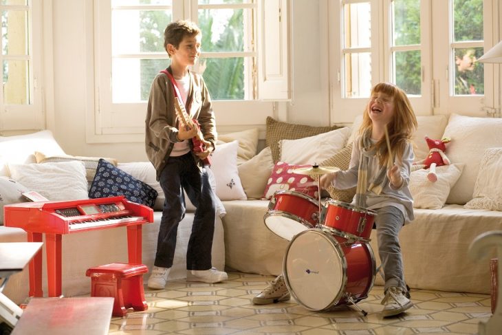 niños tocando instrumentos musicales en casa